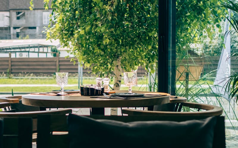 Outdoor restaurant patio with seating and greenery
